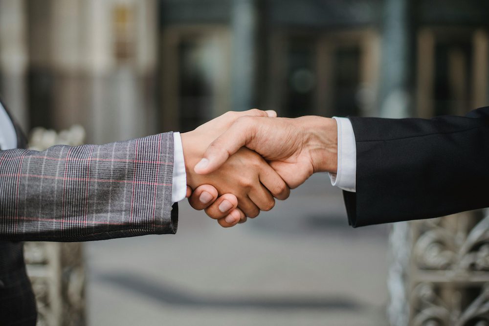 Imagen de personas dándose la mano para cerrar un trato: traspasos