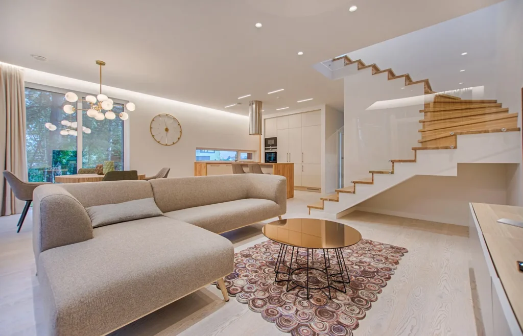 Salón de vivienda con escalera de madera, vender piso en Inmobiliaria en Barcelona
